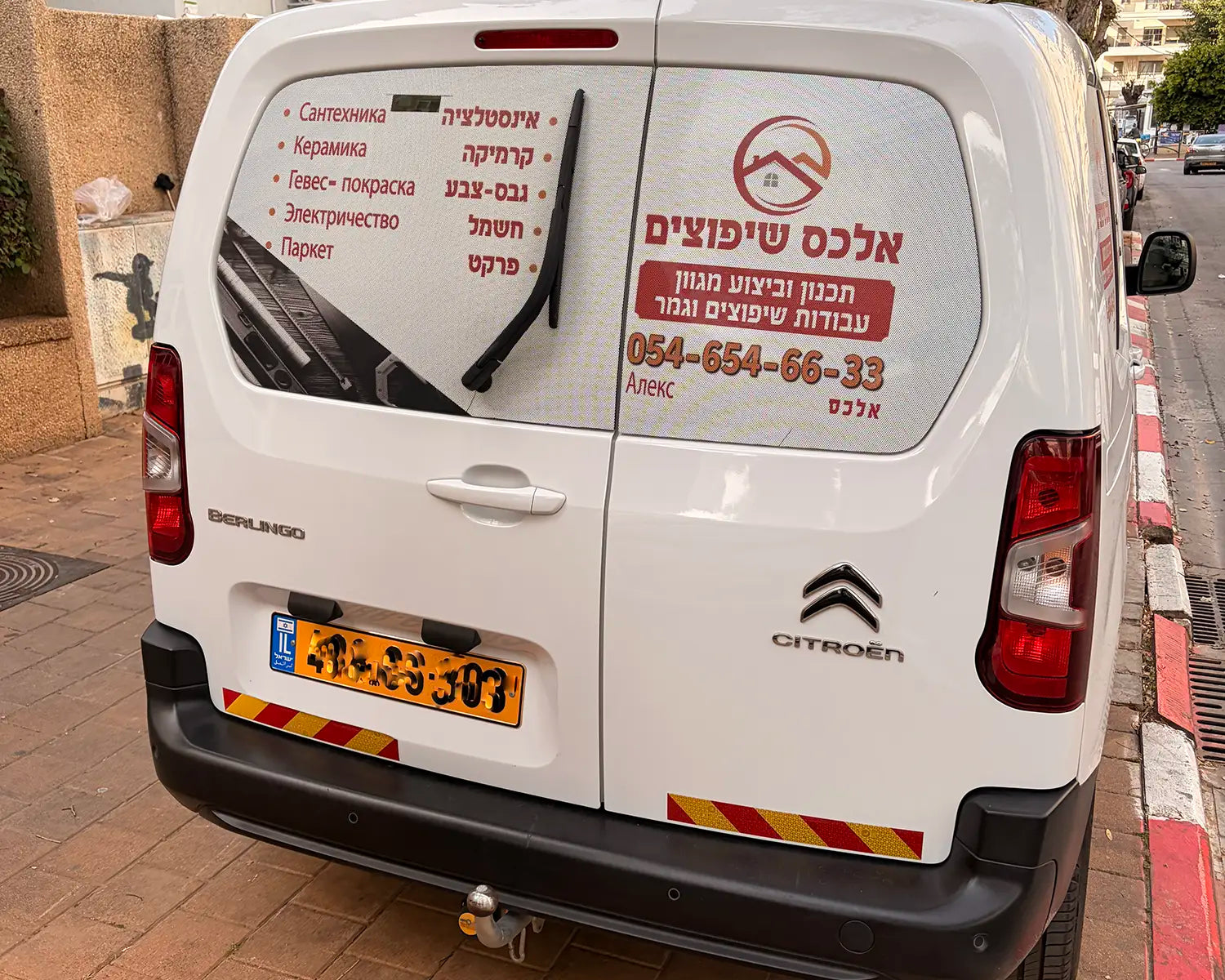 מדבקת רשת לחלון אחורי של סיטרואן ברלינגו עם לוגו ופרטי התקשרות לעסק, ראות מלאה מבפנים