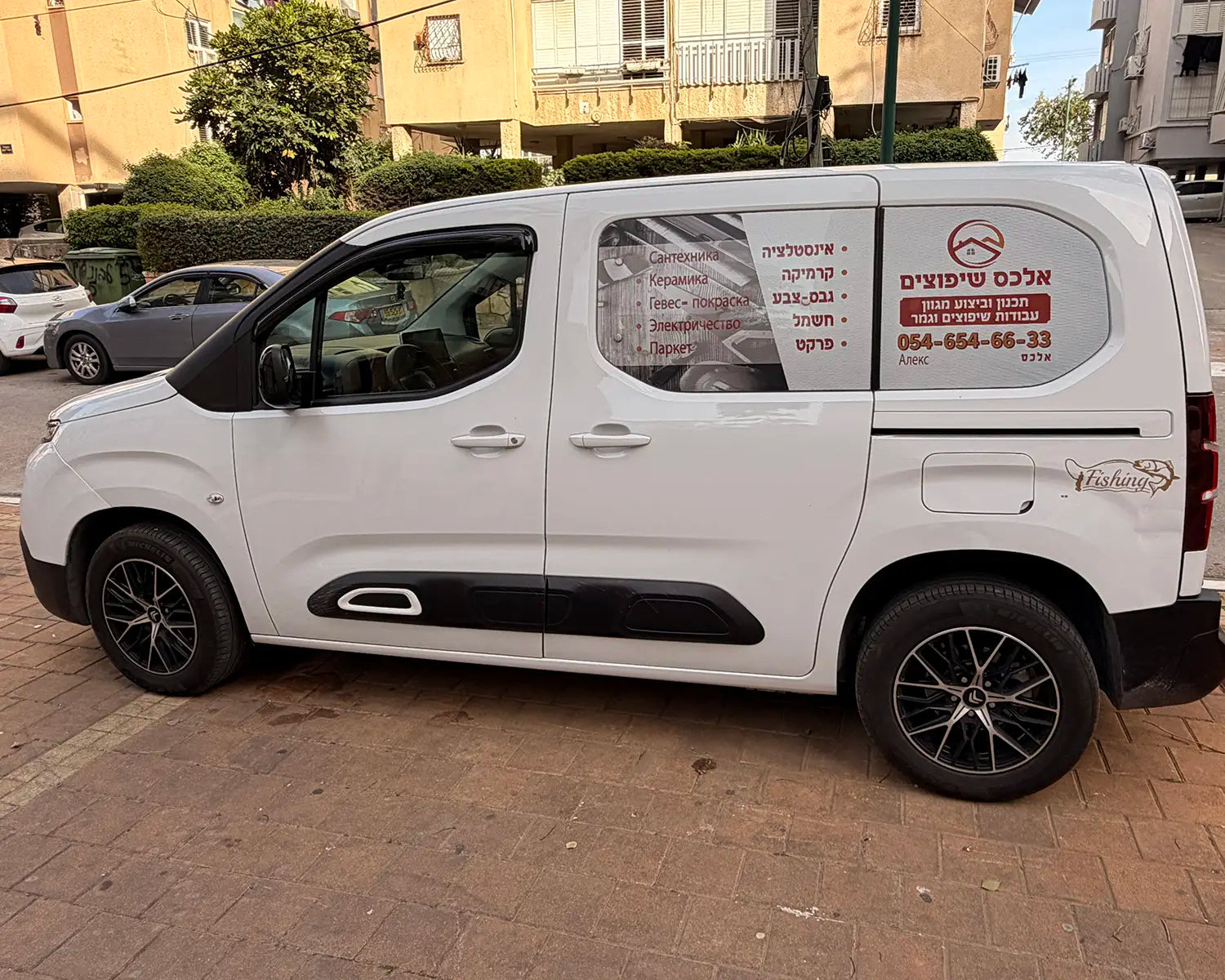 פרסום על חלון צד אחורי ברכב מסחרי קטן, מדבקת ויניל מחוררת בעיצוב אישי לשיפוצניקים ובעלי עסקים