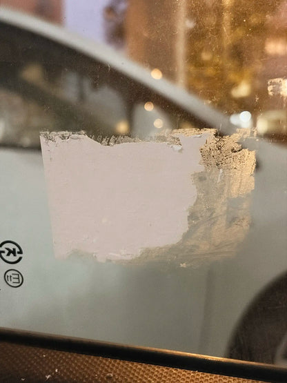 שאריות מדבקת איסור חנייה לאחר ניסיון קילוף מחלון רכב