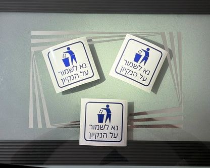 סט מדבקות קטנות בעיצוב אישי של Adboy עם הכיתוב 'נא לשמור על ניקיון', מודבקות בתוך מעלית מודרנית